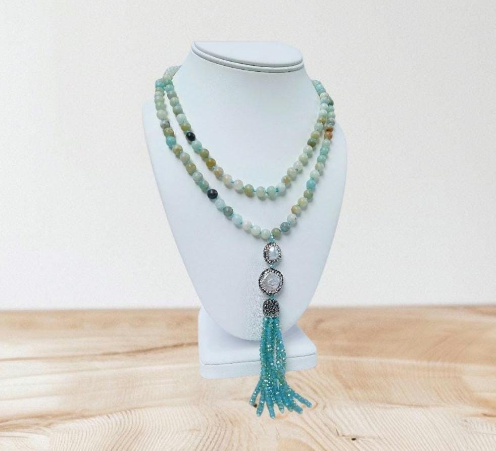 Amazonite and Pearl Necklace featuring handmade beaded crystals crafted into a bohemian long necklace with yoga charm beads and tassel accents. This unique jewelry piece blends soothing amazonite stones with elegant pearls, creating a versatile accessory perfect for spiritual practice or everyday wear. Lightweight and stylish, it makes a thoughtful gift for her, combining artisanal craftsmanship with calming energy and boho-chic design for women who appreciate meaningful jewelry.