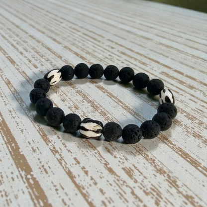 Tibetan Bone Bracelet with 12mm black lava stone beads, designed as a stretch diffuser bracelet for meditation and grounding. This handmade men’s bracelet combines traditional Tibetan jewelry elements with natural lava stones, perfect for essential oils. A meaningful lucky charm and spiritual accessory, ideal for promoting calm and focus. Great handmade gift for him—perfect for yoga, wellness, or daily wear with intention and style.