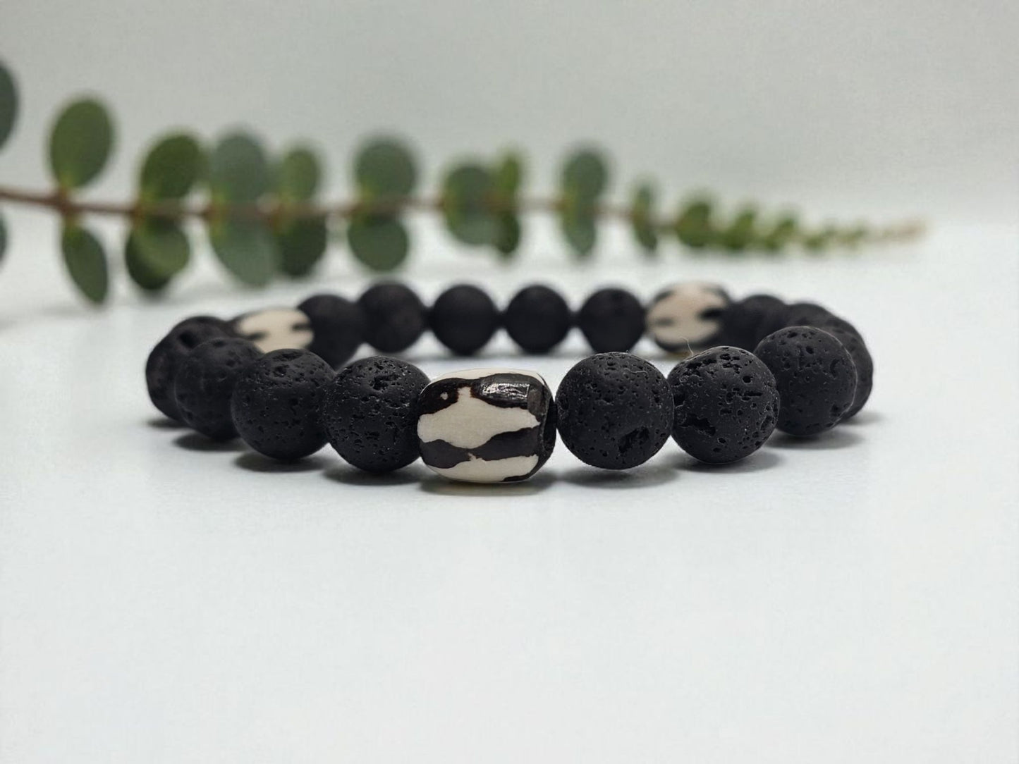 Tibetan Bone Bracelet with 12mm black lava stone beads, designed as a stretch diffuser bracelet for meditation and grounding. This handmade men’s bracelet combines traditional Tibetan jewelry elements with natural lava stones, perfect for essential oils. A meaningful lucky charm and spiritual accessory, ideal for promoting calm and focus. Great handmade gift for him—perfect for yoga, wellness, or daily wear with intention and style.