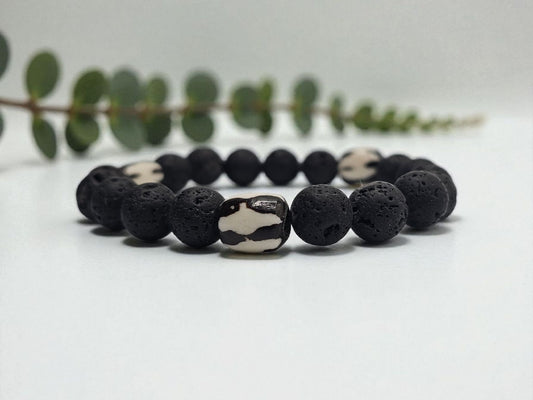 Tibetan Bone Bracelet with 12mm black lava stone beads, designed as a stretch diffuser bracelet for meditation and grounding. This handmade men’s bracelet combines traditional Tibetan jewelry elements with natural lava stones, perfect for essential oils. A meaningful lucky charm and spiritual accessory, ideal for promoting calm and focus. Great handmade gift for him—perfect for yoga, wellness, or daily wear with intention and style.