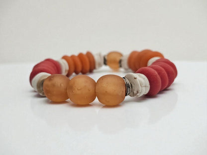 African Ashanti Glass Beaded Bracelet featuring large chunky beads in vibrant orange, red, and white colors, handcrafted into a bold statement jewelry piece for women. This lucky charm Buddha bracelet blends traditional African craftsmanship with modern style, promoting positive energy and spiritual protection. Perfect as a unique gift for her, it combines artisanal quality with eye-catching colors, ideal for everyday wear or special occasions.