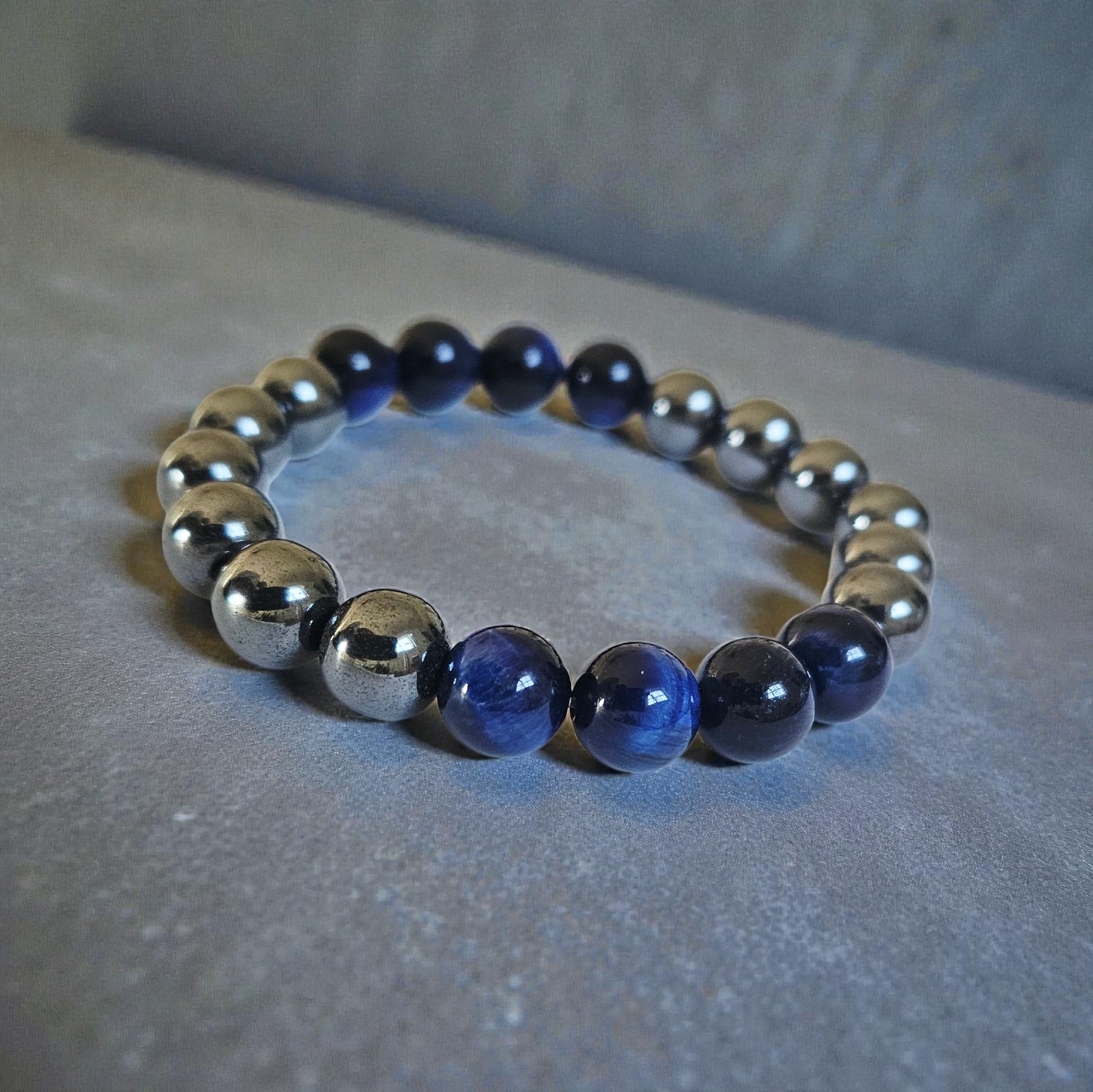 Blue Tiger Eye Hematite Bracelet handcrafted with natural stones including lapis lazuli, polished hematite, and deep blue tiger eye. This unisex stretch bracelet blends style and energy, offering grounding, focus, and protection. A perfect lucky charm and thoughtful gift for men or women, ideal for daily wear or spiritual practice. Handmade with care, this natural stone bracelet is a unique accessory for those who value wellness and intentional living.