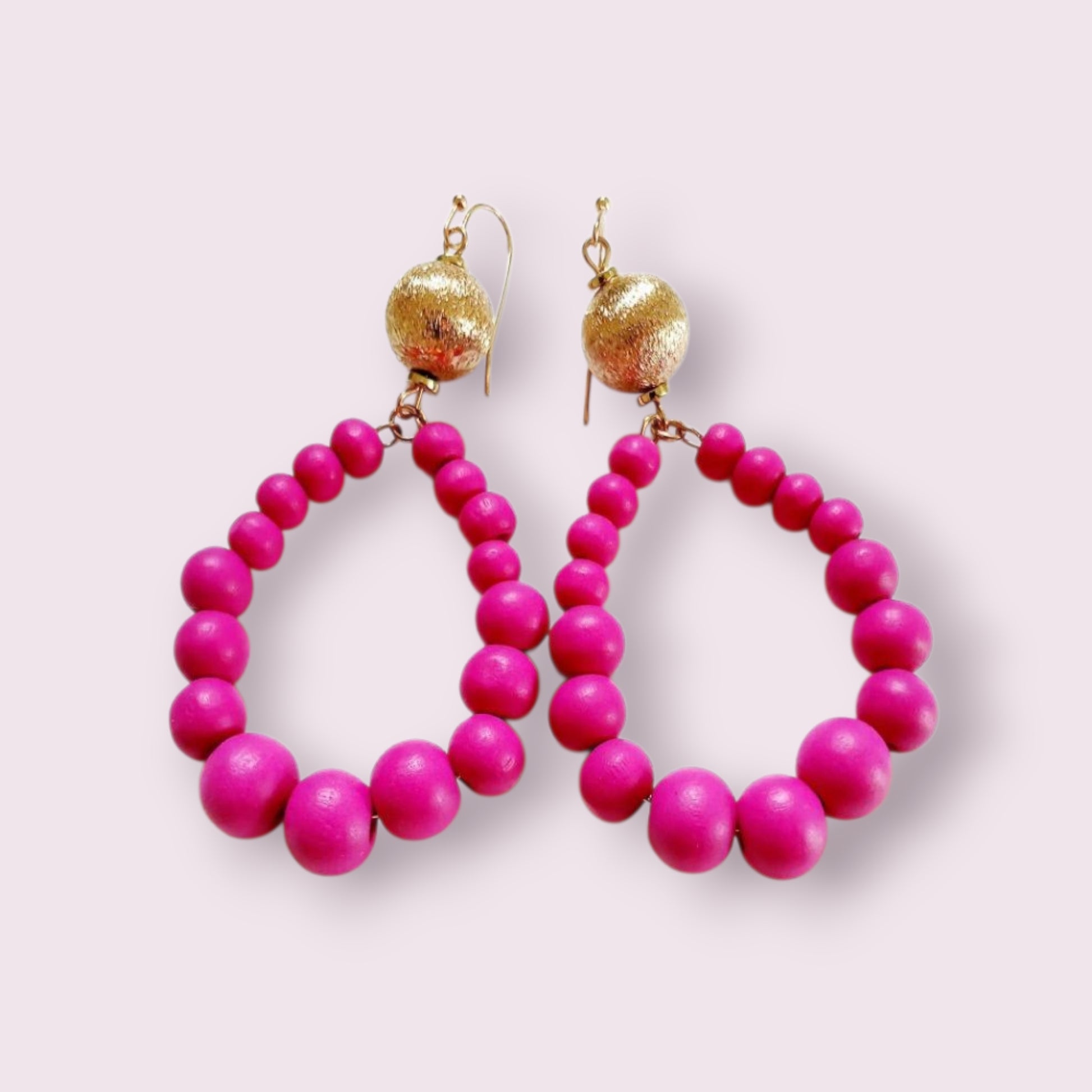 Fuchsia Resin Teardrop Hoop Earrings combined with natural wood beaded round dangles, creating a unique handmade boho statement piece for women. These vibrant, lightweight earrings blend bold resin color with earthy textures, perfect for adding a pop of color and artistic flair to any outfit. Ideal as a thoughtful gift or festival accessory, they showcase expert craftsmanship and a stylish mix of modern and natural elements for free-spirited, fashion-forward individuals.