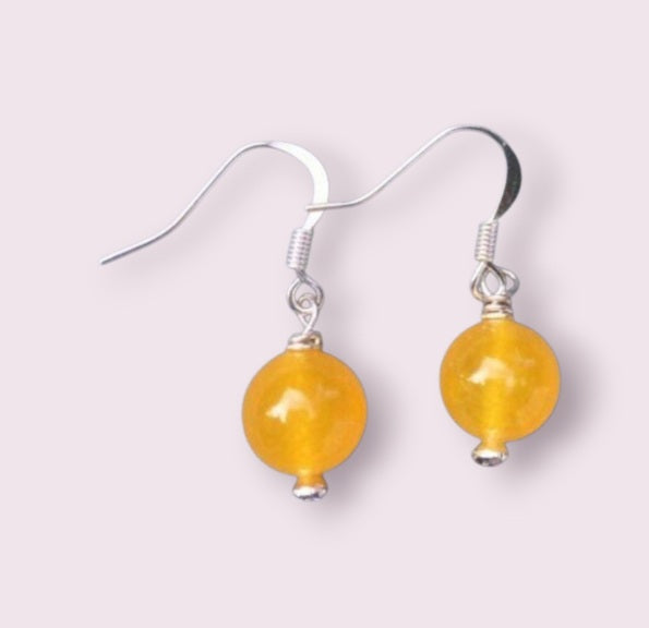 Handcrafted Yellow Jade Earrings featuring round gemstone beads paired with elegant topaz drop accents. These handmade jade jewelry pieces showcase a sophisticated design perfect for women who appreciate natural gemstones and timeless elegance. Lightweight and stylish, they make a thoughtful gift for special occasions or everyday wear. Combining artisanal craftsmanship with vibrant yellow jade and sparkling topaz, these earrings add a graceful touch to any outfit.