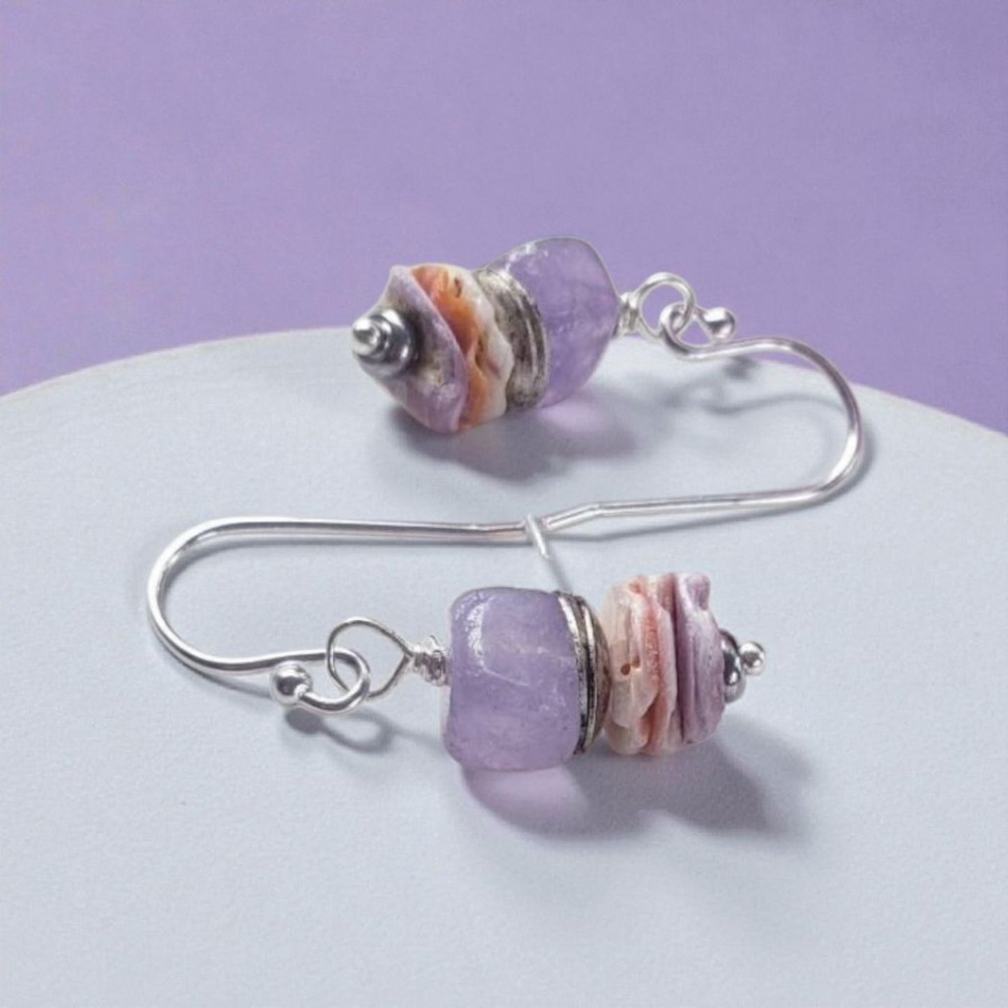 Purple Morganite Minimalist Earrings crafted in sterling silver with 8mm gemstone accents and delicate pectin scallop shell design. These handmade ocean-inspired earrings offer a soft, elegant touch for women who love beach-themed or nautical jewelry. Perfect as a thoughtful gift, bridesmaid accessory, or everyday wear. Lightweight and stylish, they blend natural beauty with minimalist charm, making them ideal for coastal weddings, summer fashion, or ocean lovers.