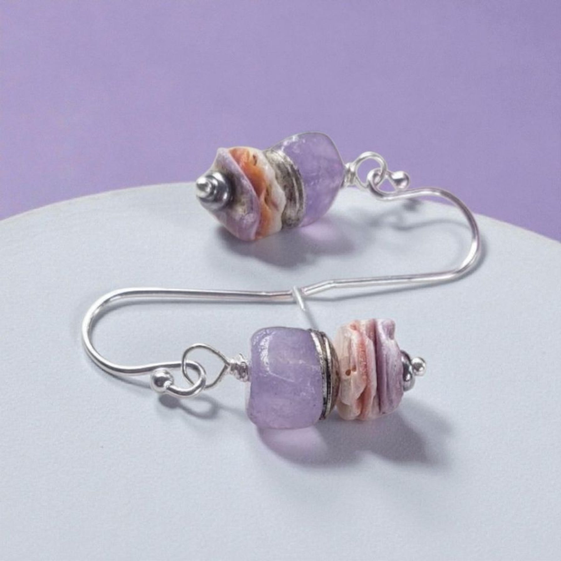 Purple Morganite Minimalist Earrings crafted in sterling silver with 8mm gemstone accents and delicate pectin scallop shell design. These handmade ocean-inspired earrings offer a soft, elegant touch for women who love beach-themed or nautical jewelry. Perfect as a thoughtful gift, bridesmaid accessory, or everyday wear. Lightweight and stylish, they blend natural beauty with minimalist charm, making them ideal for coastal weddings, summer fashion, or ocean lovers.