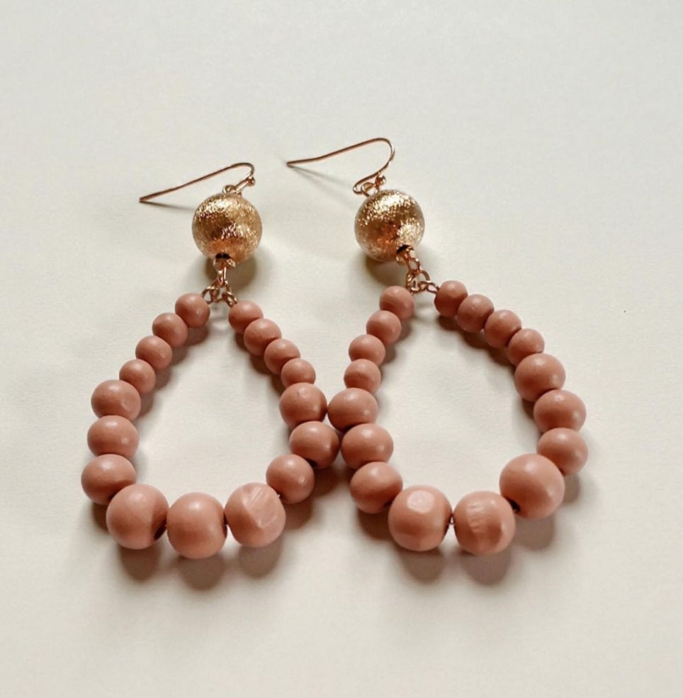 Peach resin teardrop earrings with a boho-inspired design, featuring lightweight wood bead dangles. Handmade earrings with warm, earthy tones, perfect for casual outfits, summer styles, or bohemian accessories.