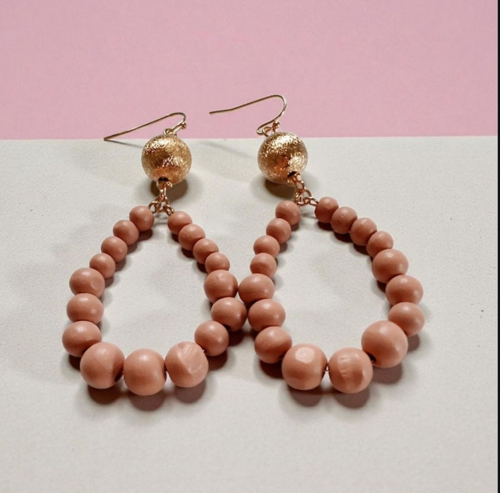 Peach resin teardrop earrings with a boho-inspired design, featuring lightweight wood bead dangles. Handmade earrings with warm, earthy tones, perfect for casual outfits, summer styles, or bohemian accessories.