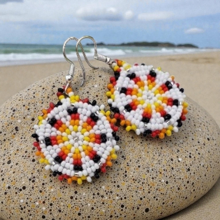 Handmade white and yellow beaded earrings in native ethnic style, featuring intricate tribal medallion design. These artisan statement earrings are perfect for women who appreciate unique, handcrafted jewelry inspired by traditional tribal patterns. Lightweight and bold, they make an excellent gift and add a touch of cultural elegance to any outfit, ideal for everyday wear or special occasions with a vibrant ethnic flair.