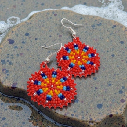 Red Handmade Beaded Earrings for women featuring vibrant native-style beadwork with multicolor accents in a bold boho medallion design. These statement festival earrings showcase intricate craftsmanship and colorful patterns, perfect for adding a pop of color to any outfit. Ideal gift for women who appreciate unique, artisanal jewelry with cultural significance. Lightweight and striking, these earrings elevate both casual and festive looks with artistic flair.