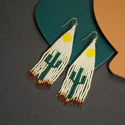 Cactus Earrings featuring Southwest-style glass beadwork with large tassels and fringe design, handmade statement jewelry for women. These colorful earrings showcase intricate bead patterns inspired by desert motifs, perfect for adding bold flair to boho or festival outfits. Lightweight and eye-catching, they make a thoughtful handmade gift for women who love unique, artisanal accessories with southwestern charm and vibrant style.