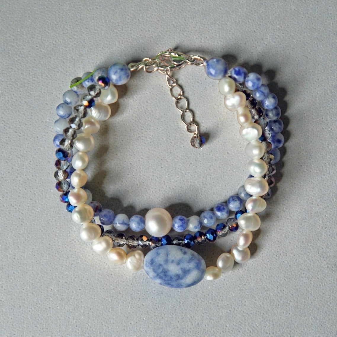 Handmade multi-strand bracelet featuring sodalite and cultured pearl beads, designed as chunky crystal jewelry with a minimalist pendant accent. This beaded bracelet offers a stylish and elegant accessory perfect for girls who love unique, handcrafted pieces. Combining natural gemstones with delicate craftsmanship, it makes a thoughtful gift ideal for special occasions or everyday wear, blending boho charm with modern minimalist style.