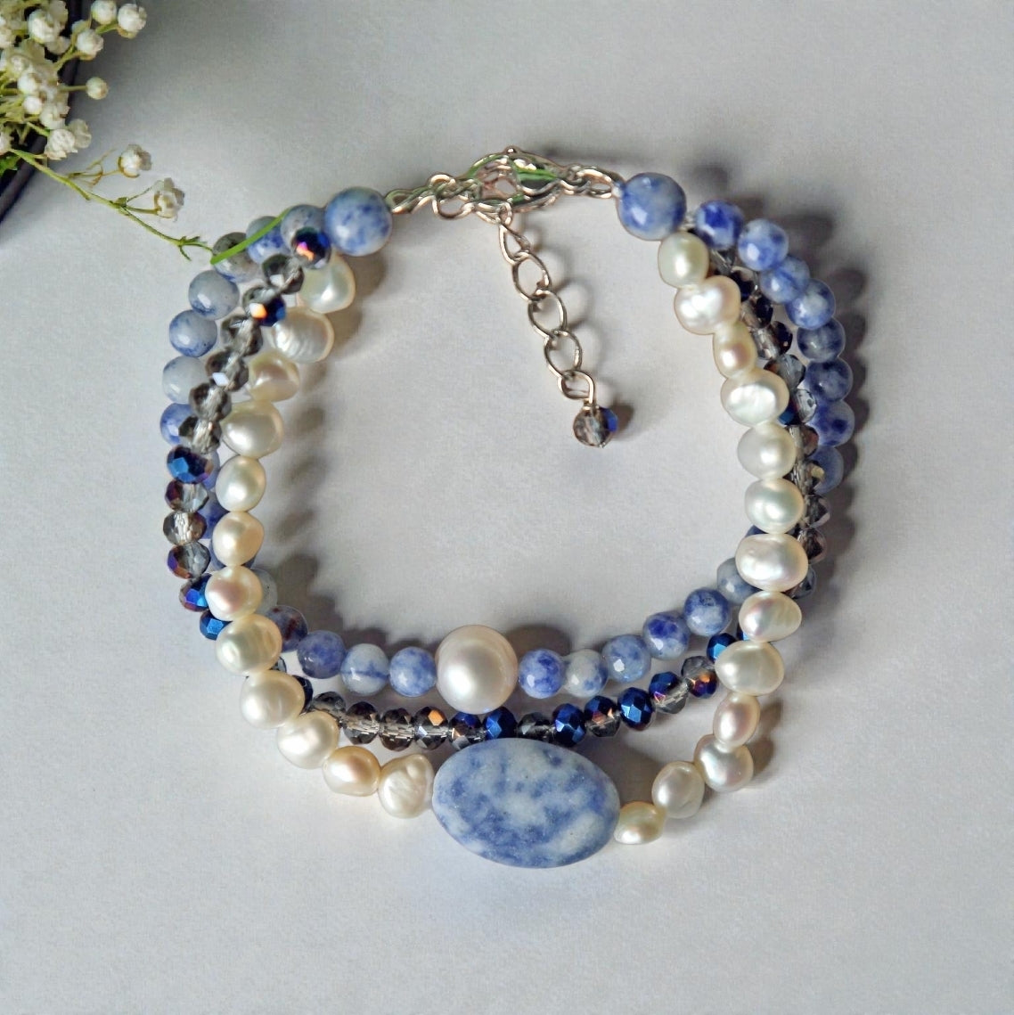 Handmade multi-strand bracelet featuring sodalite and cultured pearl beads, designed as chunky crystal jewelry with a minimalist pendant accent. This beaded bracelet offers a stylish and elegant accessory perfect for girls who love unique, handcrafted pieces. Combining natural gemstones with delicate craftsmanship, it makes a thoughtful gift ideal for special occasions or everyday wear, blending boho charm with modern minimalist style.