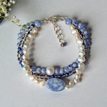 Handmade multi-strand bracelet featuring sodalite and cultured pearl beads, designed as chunky crystal jewelry with a minimalist pendant accent. This beaded bracelet offers a stylish and elegant accessory perfect for girls who love unique, handcrafted pieces. Combining natural gemstones with delicate craftsmanship, it makes a thoughtful gift ideal for special occasions or everyday wear, blending boho charm with modern minimalist style.