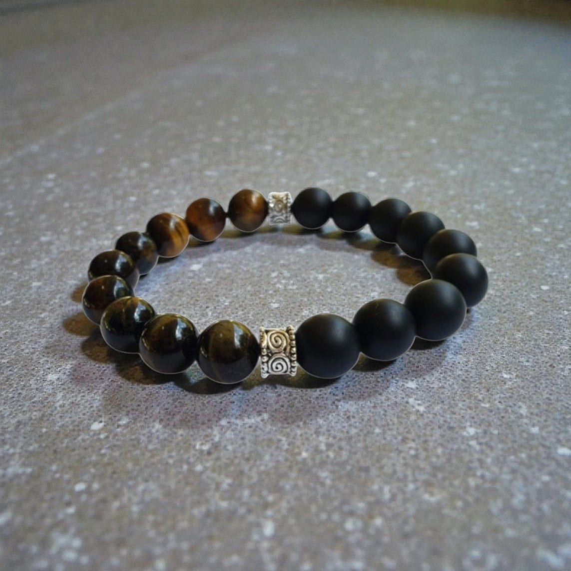 Handmade men’s bracelet featuring natural tiger’s eye and black onyx stones set in a sleek sterling silver bar design. This stylish accessory combines powerful lucky charm stones, known for their protective and grounding properties, making it an ideal birthday gift or meaningful jewelry piece. Perfect for men who appreciate handcrafted, elegant, and masculine jewelry that blends natural elements with modern style.