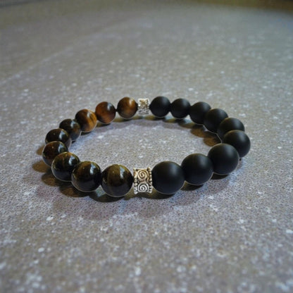 Handmade men’s bracelet featuring natural tiger’s eye and black onyx stones set in a sleek sterling silver bar design. This stylish accessory combines powerful lucky charm stones, known for their protective and grounding properties, making it an ideal birthday gift or meaningful jewelry piece. Perfect for men who appreciate handcrafted, elegant, and masculine jewelry that blends natural elements with modern style.