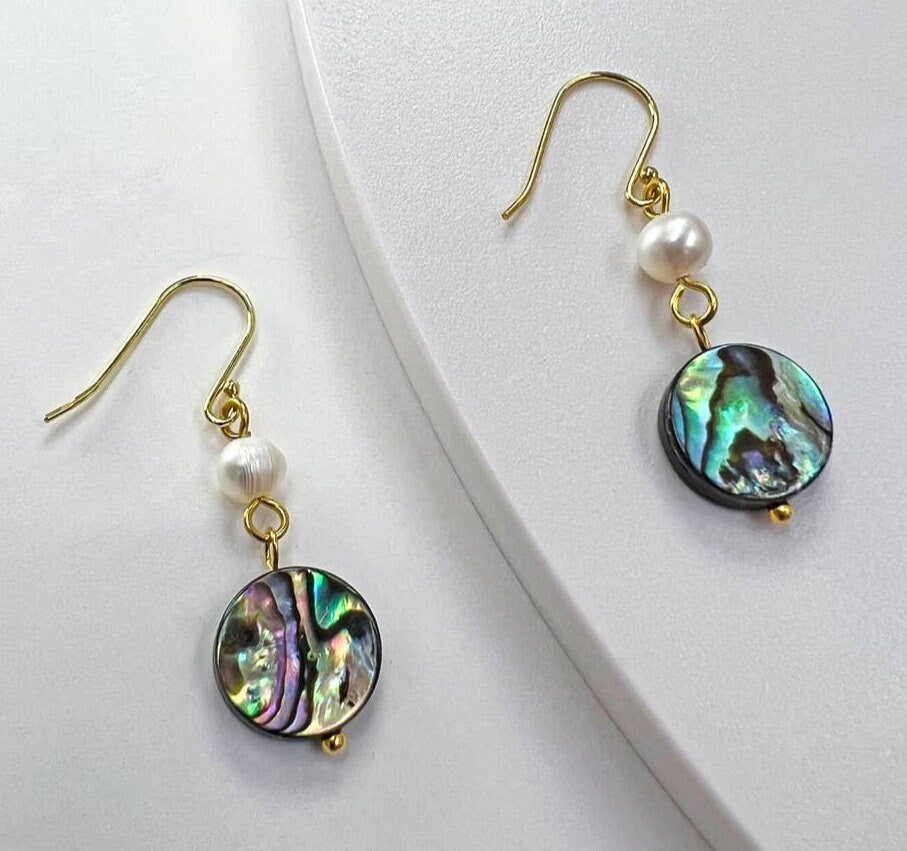 Handmade Abalone Shell Drop Earrings featuring iridescent coin shell pearls in a lightweight dangle design. These dainty and unique earrings for women showcase natural abalone hues with shimmering color shifts, making them a stunning accessory for any outfit. A perfect gift for her, these artisanal earrings blend elegance and simplicity, ideal for birthdays, anniversaries, or special occasions. Stylish, feminine, and one of a kind.