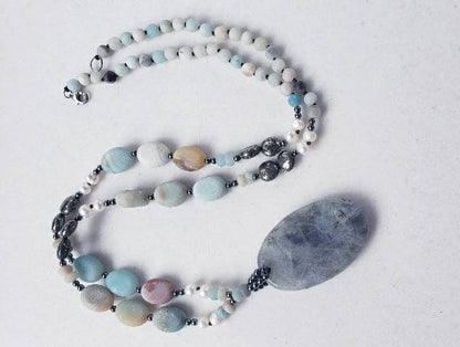 Amazonite and labradorite crystal necklace for women featuring a natural gemstone pendant with soothing tones and subtle shimmer. This handmade statement necklace blends calming amazonite with the iridescent glow of labradorite, offering both beauty and spiritual meaning. Perfect for boho or everyday wear, it makes a thoughtful gift for her. Crafted with care, this unique piece adds a touch of elegance and grounding energy to any jewelry collection