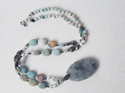 Amazonite and labradorite crystal necklace for women featuring a natural gemstone pendant with soothing tones and subtle shimmer. This handmade statement necklace blends calming amazonite with the iridescent glow of labradorite, offering both beauty and spiritual meaning. Perfect for boho or everyday wear, it makes a thoughtful gift for her. Crafted with care, this unique piece adds a touch of elegance and grounding energy to any jewelry collection