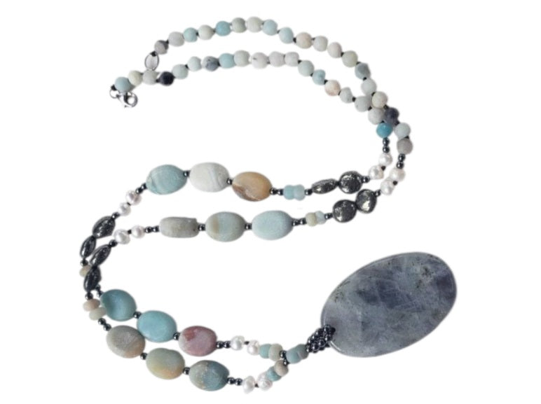 Long beaded amazonite necklace for women featuring pearls, labradorite, hematite, and pyrite for a bold statement look. This handcrafted necklace blends soft and earthy tones with natural gemstones known for their beauty and healing properties. Perfect for layering or wearing alone, it adds elegance to boho and everyday styles. A unique gift for her, this versatile necklace brings together calming energy and sophisticated design in one stunning piece.