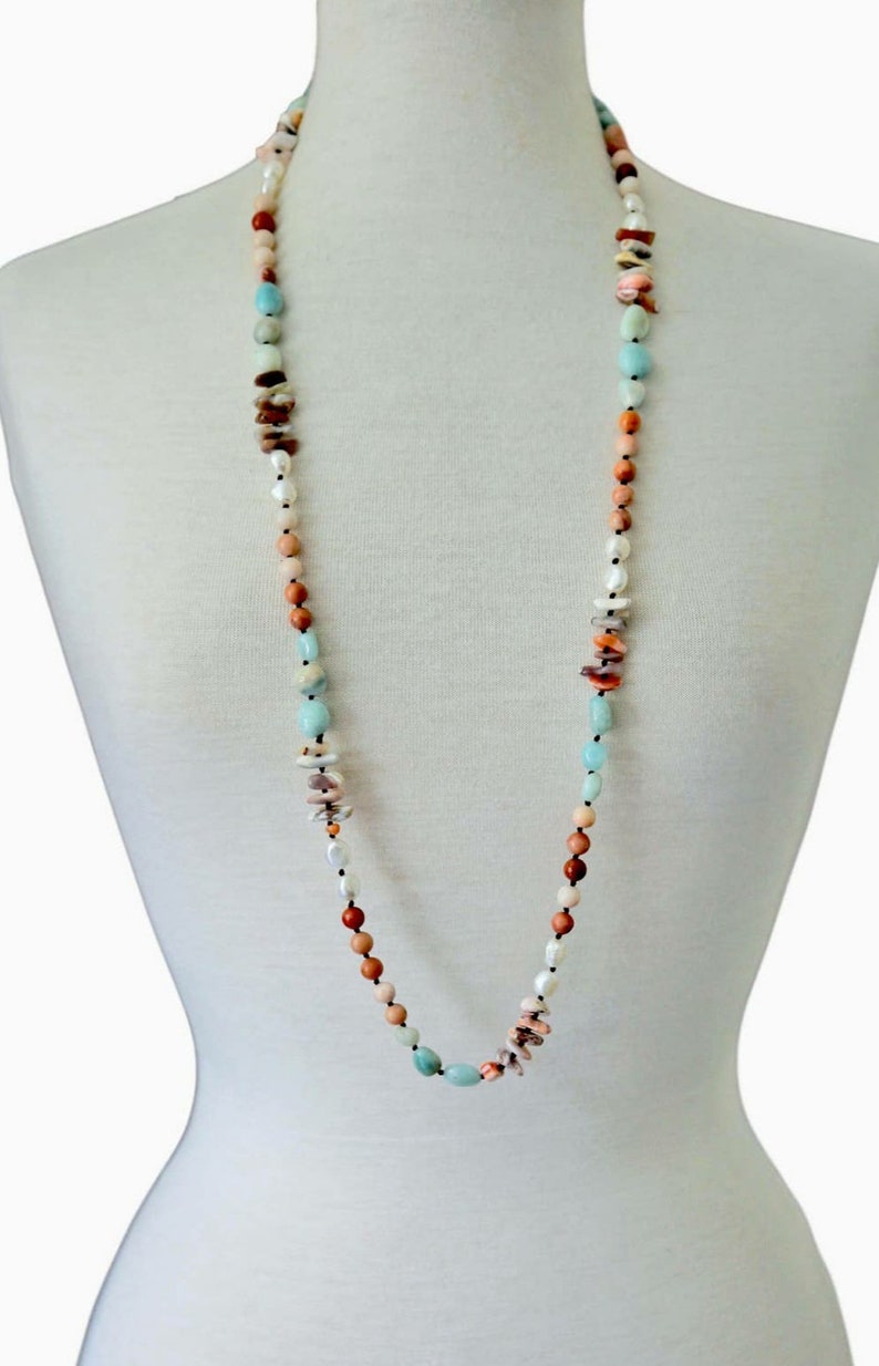Handmade long necklace featuring natural amazonite and agate gemstones in green and blue hues, designed as a vintage-inspired statement crystal jewelry piece. This unique accessory blends earthy elegance with artisanal craftsmanship, perfect for women who appreciate handcrafted gemstone jewelry. Ideal as a Christmas gift for her, it adds a pop of color and spiritual energy to any outfit, suitable for both casual and formal occasions.