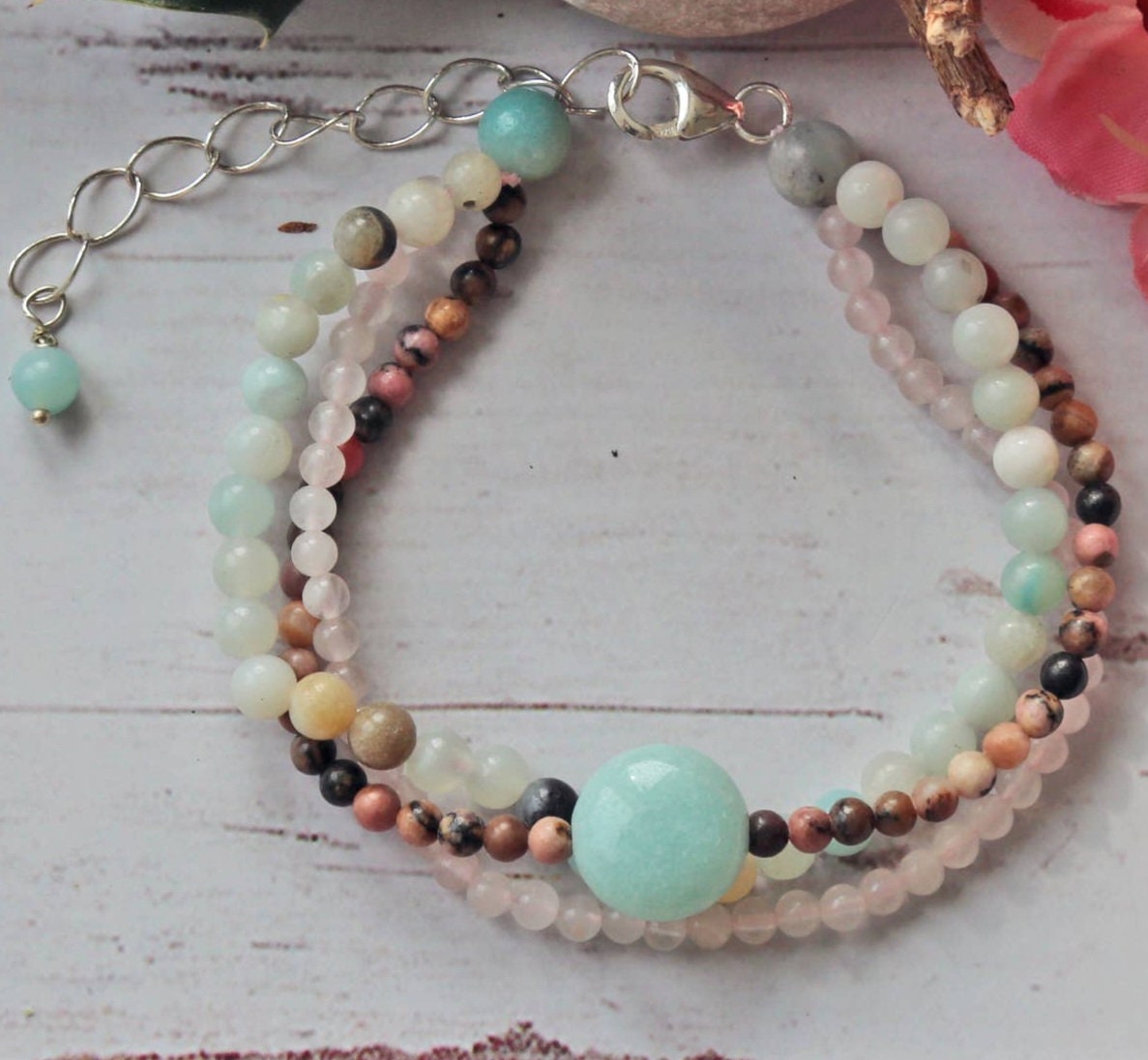 Beautiful multi-strand beaded bracelet for women featuring Amazonite, Rhodonite, Rose Quartz, and freshwater Pearls, accented with sterling silver details. This handmade healing gemstone jewelry promotes emotional balance and love, making it a meaningful gift for her. Perfect for special occasions or everyday wear, this elegant bracelet combines natural colors and textures for a stylish, feminine accessory that enhances any outfit
