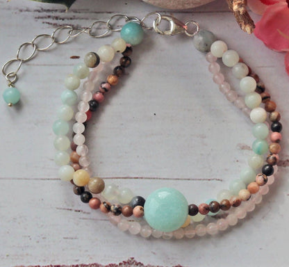 Beautiful multi-strand beaded bracelet for women featuring Amazonite, Rhodonite, Rose Quartz, and freshwater Pearls, accented with sterling silver details. This handmade healing gemstone jewelry promotes emotional balance and love, making it a meaningful gift for her. Perfect for special occasions or everyday wear, this elegant bracelet combines natural colors and textures for a stylish, feminine accessory that enhances any outfit
