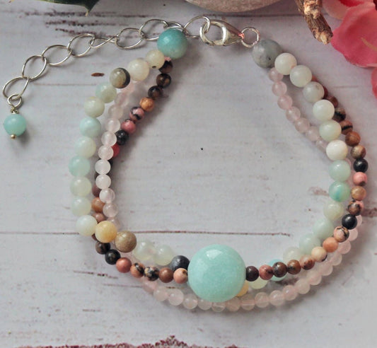 Beautiful multi-strand beaded bracelet for women featuring Amazonite, Rhodonite, Rose Quartz, and freshwater Pearls, accented with sterling silver details. This handmade healing gemstone jewelry promotes emotional balance and love, making it a meaningful gift for her. Perfect for special occasions or everyday wear, this elegant bracelet combines natural colors and textures for a stylish, feminine accessory that enhances any outfit