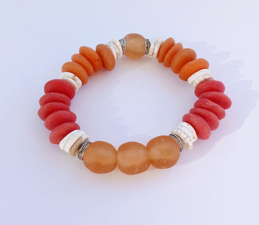 African Ashanti Glass Beaded Bracelet featuring large chunky beads in vibrant orange, red, and white colors, handcrafted into a bold statement jewelry piece for women. This lucky charm Buddha bracelet blends traditional African craftsmanship with modern style, promoting positive energy and spiritual protection. Perfect as a unique gift for her, it combines artisanal quality with eye-catching colors, ideal for everyday wear or special occasions.
