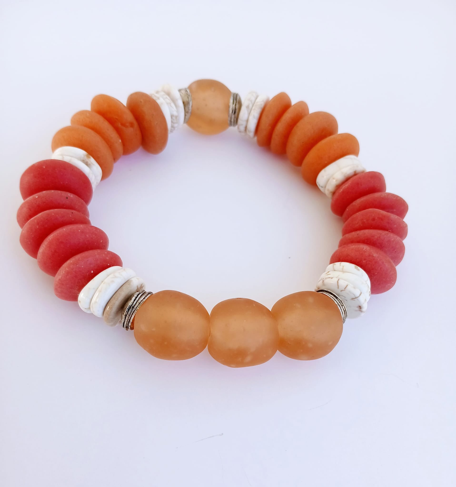 African Ashanti Glass Beaded Bracelet featuring large chunky beads in vibrant orange, red, and white colors, handcrafted into a bold statement jewelry piece for women. This lucky charm Buddha bracelet blends traditional African craftsmanship with modern style, promoting positive energy and spiritual protection. Perfect as a unique gift for her, it combines artisanal quality with eye-catching colors, ideal for everyday wear or special occasions.