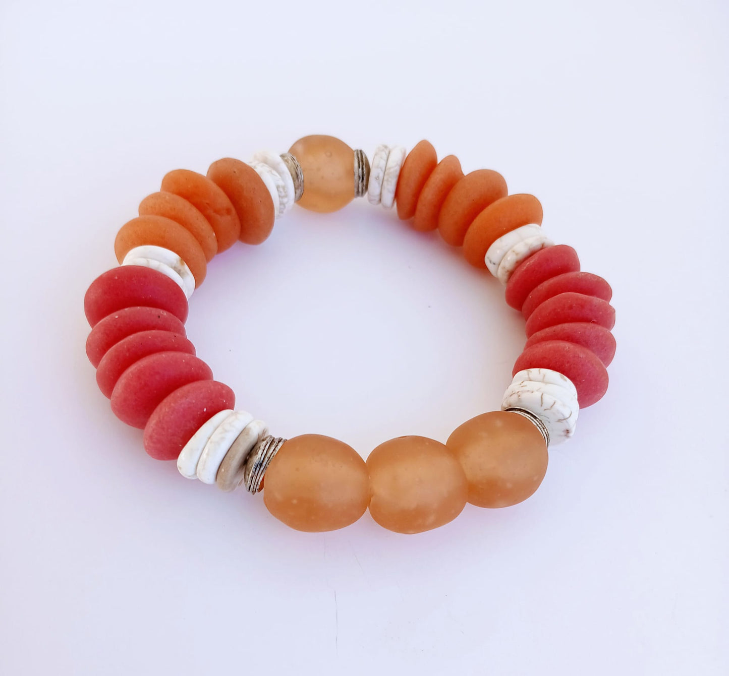 African Ashanti Glass Beaded Bracelet featuring large chunky beads in vibrant orange, red, and white colors, handcrafted into a bold statement jewelry piece for women. This lucky charm Buddha bracelet blends traditional African craftsmanship with modern style, promoting positive energy and spiritual protection. Perfect as a unique gift for her, it combines artisanal quality with eye-catching colors, ideal for everyday wear or special occasions.