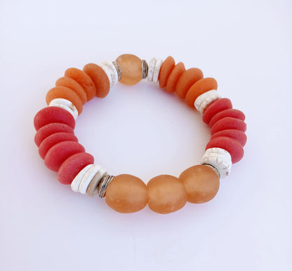 African Ashanti Glass Beaded Bracelet featuring large chunky beads in vibrant orange, red, and white colors, handcrafted into a bold statement jewelry piece for women. This lucky charm Buddha bracelet blends traditional African craftsmanship with modern style, promoting positive energy and spiritual protection. Perfect as a unique gift for her, it combines artisanal quality with eye-catching colors, ideal for everyday wear or special occasions.