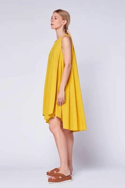 Asymmetrical Midi Tank Dress in mustard color crafted from soft cotton, designed for women seeking stylish comfort. This sleeveless, oversized summer dress features a unique asymmetrical hemline and breathable fabric, making it perfect for casual boho-inspired looks. Made in Italy with high-quality craftsmanship, it blends relaxed fit with elegant design for warm-weather outings or laid-back gatherings.