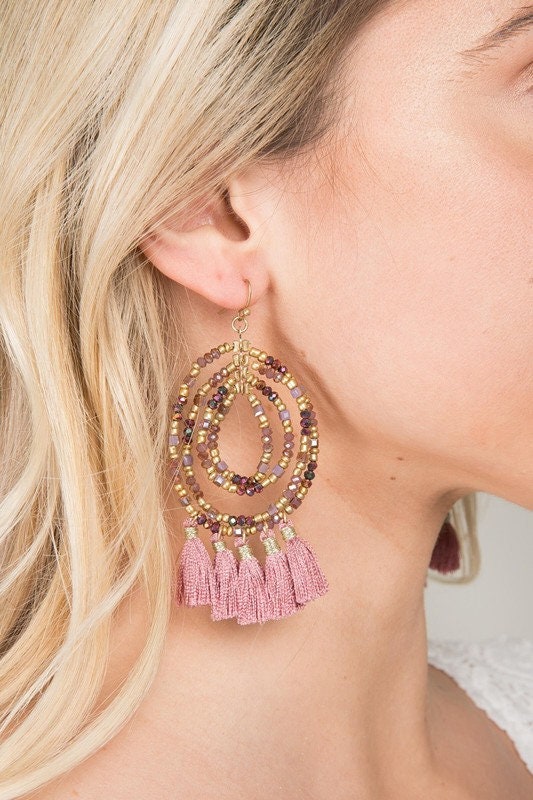 Beaded Hoop Tassel Earrings for women featuring large, handmade designs with intricate beadwork and flowing tassels. These unique boho statement earrings combine vibrant colors and textures, perfect for adding bold flair to any outfit. Lightweight and eye-catching, they make an ideal gift for women who love artisanal, handcrafted jewelry. Perfect for festivals, casual wear, or special occasions, these earrings showcase creativity and free-spirited style in a striking accessory.
