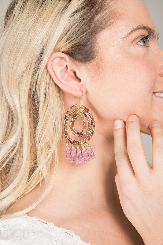 Beaded Hoop Tassel Earrings for women featuring large, handmade designs with intricate beadwork and flowing tassels. These unique boho statement earrings combine vibrant colors and textures, perfect for adding bold flair to any outfit. Lightweight and eye-catching, they make an ideal gift for women who love artisanal, handcrafted jewelry. Perfect for festivals, casual wear, or special occasions, these earrings showcase creativity and free-spirited style in a striking accessory.