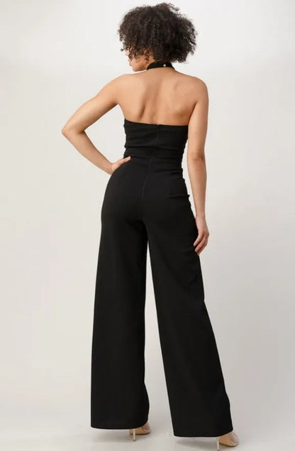 Black and gold sequin jumpsuit for women crafted from techno crepe fabric, offering a sleek and elegant one-piece evening wear option. Made in the USA, this formal party outfit features shimmering sequins that catch the light, creating a glamorous and sophisticated look. Perfect for special occasions, it combines comfort and style with a flattering fit, making it an eye-catching choice for upscale events and celebrations.