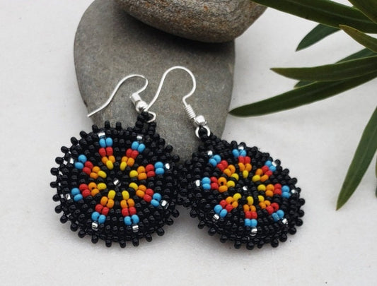 Handmade black native beaded earrings featuring southwestern-inspired design with black and blue beads. These boho tribal dangle earrings combine traditional craftsmanship with modern style, perfect for women who love unique statement jewelry. Lightweight and vibrant, they add a bold touch to any outfit. Ideal as a thoughtful gift for her, these earrings celebrate cultural artistry and complement bohemian and tribal fashion styles effortlessly