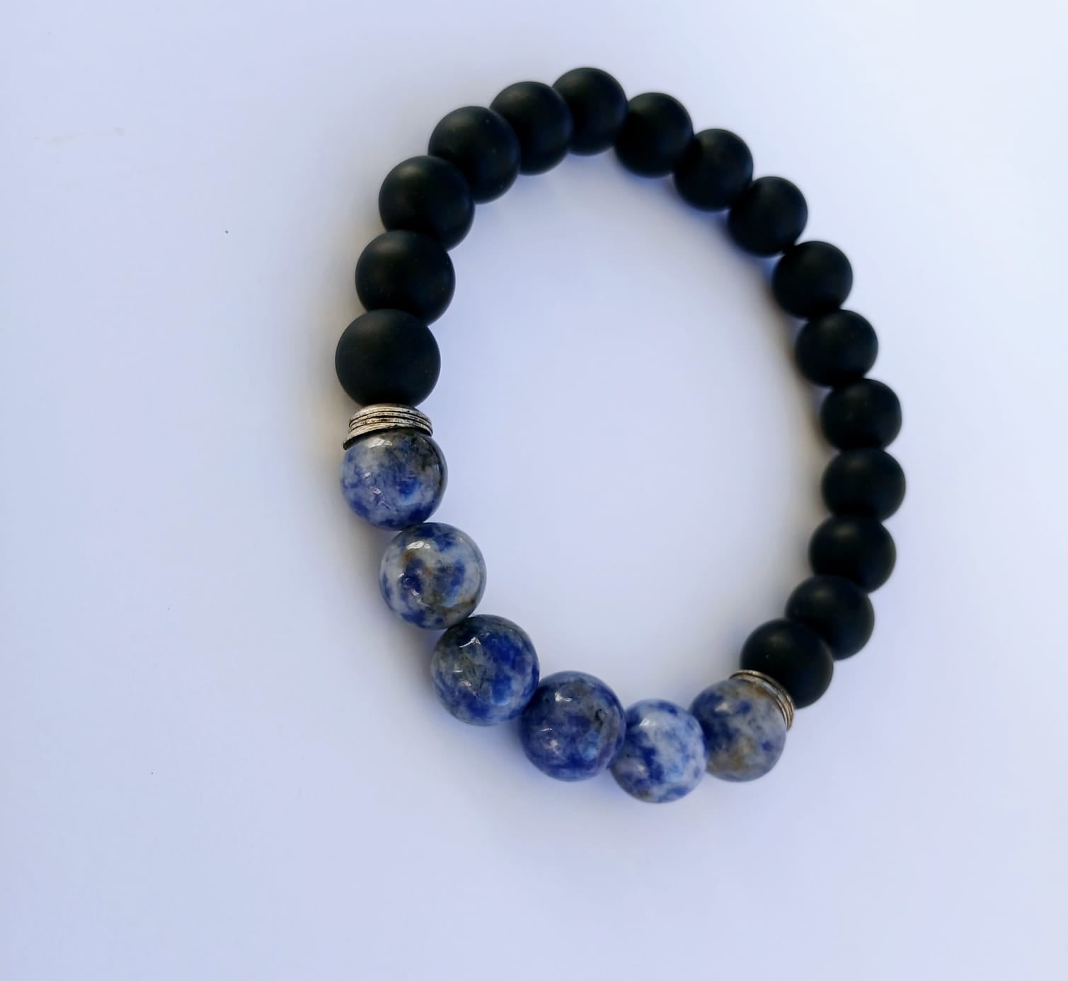 Black Onyx and Sodalite Stretch Bracelet designed for men, featuring natural stones including blue tiger eye for healing and protection. This handmade jewelry piece combines the grounding energy of onyx with the calming properties of sodalite and tiger eye, creating a stylish and meaningful accessory. Perfect as a gift for him, this stretch bracelet offers comfort, durability, and spiritual charm, ideal for everyday wear or meditation practices.