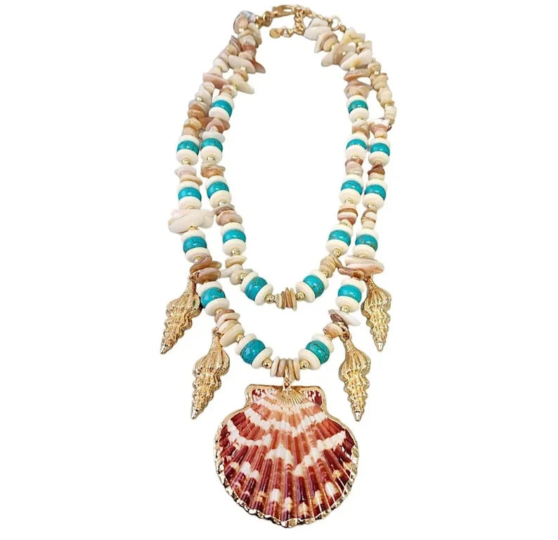 Layered seashell charm pendant necklace featuring blue, beige, and gold tones for a beachy boho look. This coastal jewelry piece captures ocean-inspired elegance with delicate shell charms and soft summer hues. Perfect for beach lovers and bohemian styles, it’s a thoughtful ocean-themed gift for her. Add a touch of seaside charm to your summer style with this lightweight, layered necklace that evokes the beauty of the coast