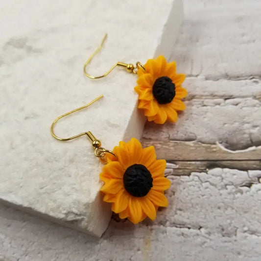 Sunflower earrings for women featuring cute yellow flower dangle design, perfect for summer and boho-inspired looks. These lightweight statement earrings add a bright, cheerful touch to any outfit and celebrate nature’s beauty. Ideal as a gift for her, these charming earrings complement casual and dressy styles alike. Made for women who love floral jewelry and want to express a fun, sunny vibe year-round with stylish, nature-inspired accessories.