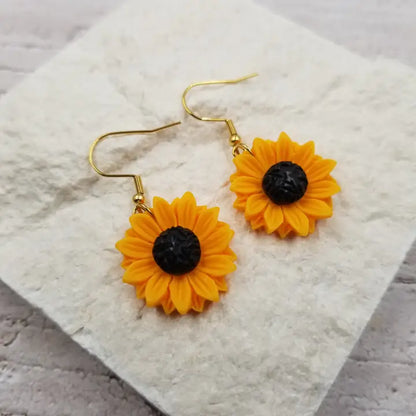 Sunflower earrings for women featuring cute yellow flower dangle design, perfect for summer and boho-inspired looks. These lightweight statement earrings add a bright, cheerful touch to any outfit and celebrate nature’s beauty. Ideal as a gift for her, these charming earrings complement casual and dressy styles alike. Made for women who love floral jewelry and want to express a fun, sunny vibe year-round with stylish, nature-inspired accessories.