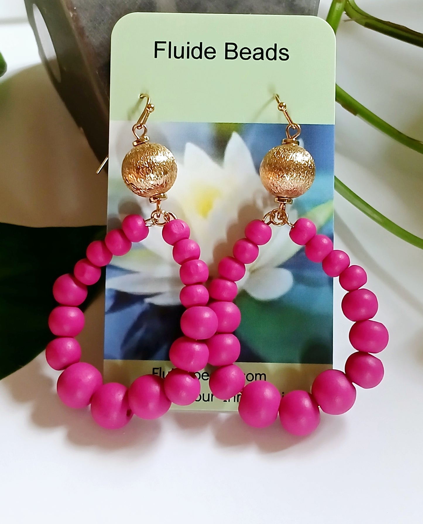 Fuchsia Resin Teardrop Hoop Earrings combined with natural wood beaded round dangles, creating a unique handmade boho statement piece for women. These vibrant, lightweight earrings blend bold resin color with earthy textures, perfect for adding a pop of color and artistic flair to any outfit. Ideal as a thoughtful gift or festival accessory, they showcase expert craftsmanship and a stylish mix of modern and natural elements for free-spirited, fashion-forward individuals.