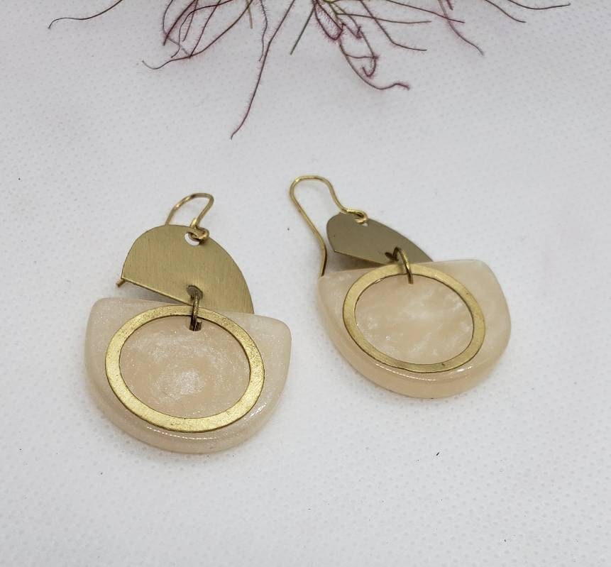 Lightweight gold resin earrings featuring modern geometric dangle design inspired by Art Deco style. These statement earrings for women combine bold shapes with a sleek finish, making them a unique accessory for everyday wear or special occasions. Handmade with attention to detail, they serve as a stylish gift for her who loves contemporary, eye-catching jewelry that blends elegance and modern artistry effortlessly.