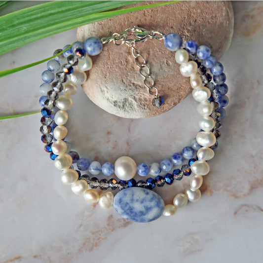Handmade multi-strand bracelet featuring sodalite and cultured pearl beads, designed as chunky crystal jewelry with a minimalist pendant accent. This beaded bracelet offers a stylish and elegant accessory perfect for girls who love unique, handcrafted pieces. Combining natural gemstones with delicate craftsmanship, it makes a thoughtful gift ideal for special occasions or everyday wear, blending boho charm with modern minimalist style.