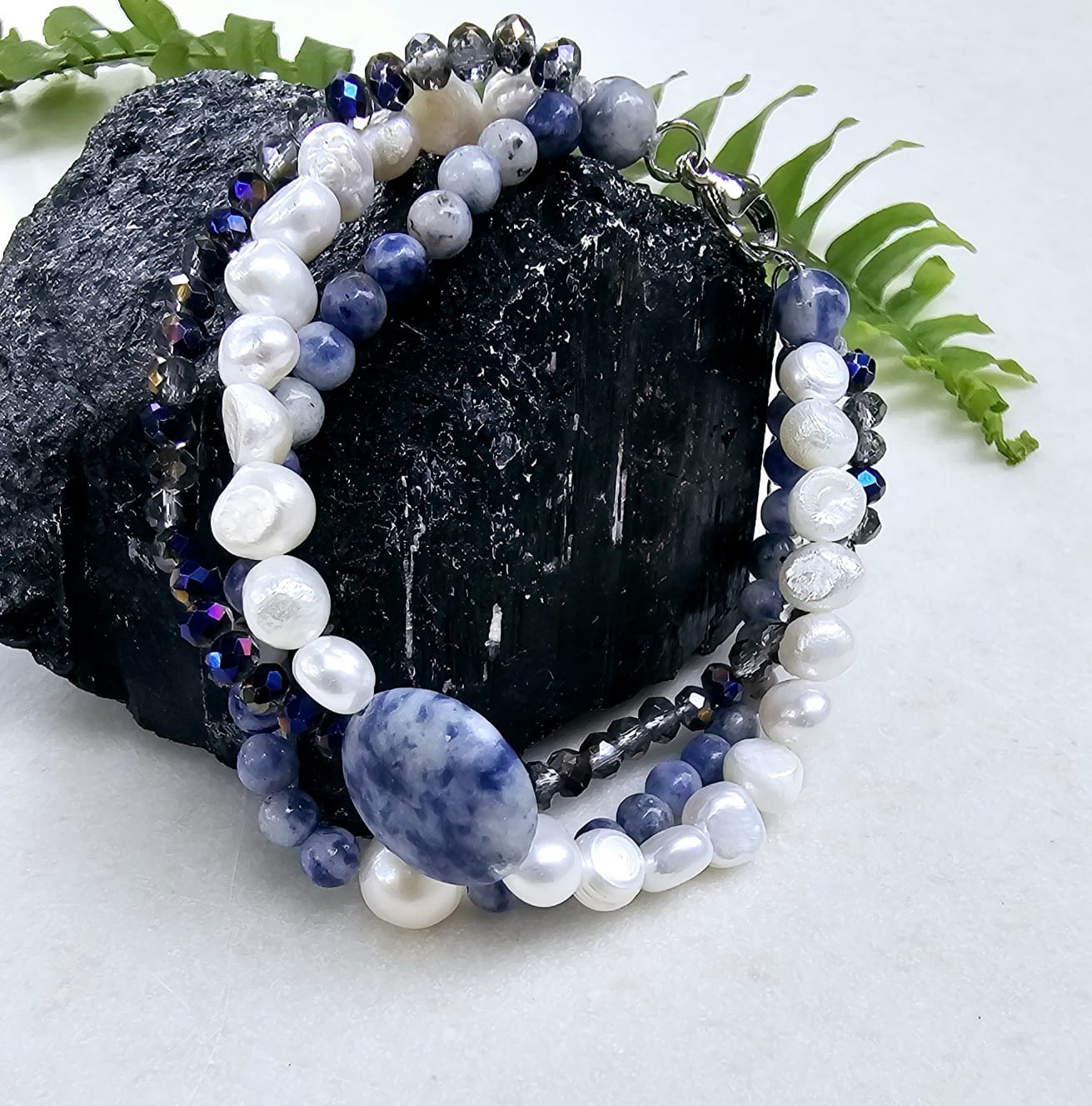Handmade multi-strand bracelet featuring sodalite and cultured pearl beads, designed as chunky crystal jewelry with a minimalist pendant accent. This beaded bracelet offers a stylish and elegant accessory perfect for girls who love unique, handcrafted pieces. Combining natural gemstones with delicate craftsmanship, it makes a thoughtful gift ideal for special occasions or everyday wear, blending boho charm with modern minimalist style.
