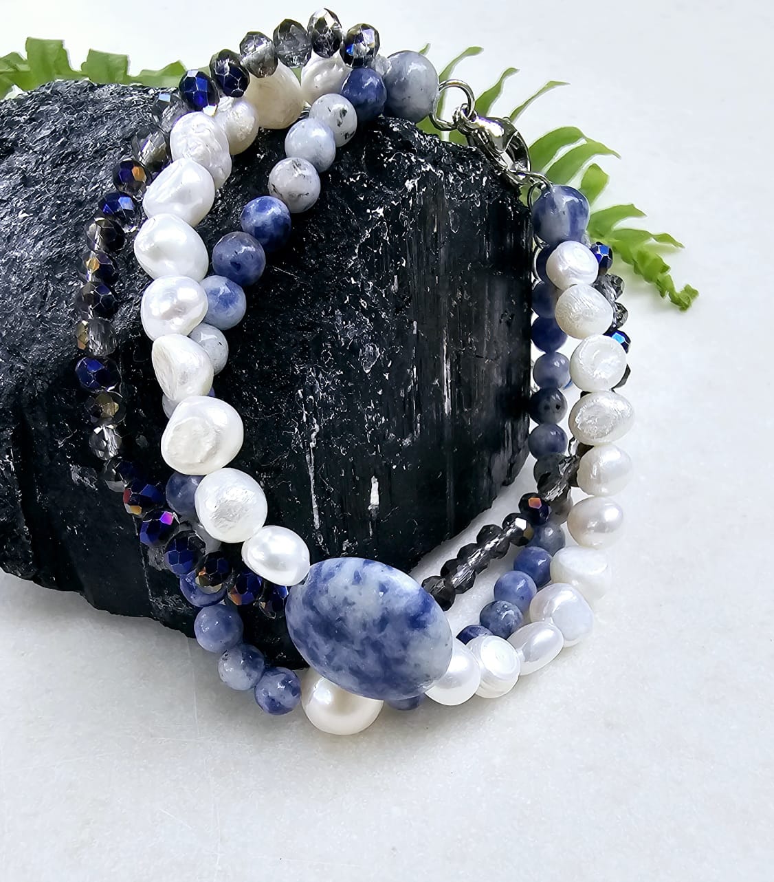 Handmade multi-strand bracelet featuring sodalite and cultured pearl beads, designed as chunky crystal jewelry with a minimalist pendant accent. This beaded bracelet offers a stylish and elegant accessory perfect for girls who love unique, handcrafted pieces. Combining natural gemstones with delicate craftsmanship, it makes a thoughtful gift ideal for special occasions or everyday wear, blending boho charm with modern minimalist style.