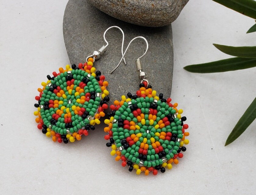Green Handmade Beaded Earrings for women featuring intricate native-style beadwork in a bold boho design. These statement green medallion earrings showcase vibrant beads arranged in festival-inspired patterns, perfect for adding color and artistry to any outfit. Ideal gift for women who love unique, handcrafted jewelry with cultural flair. Lightweight and eye-catching, these earrings complement casual and dressy looks alike, making them perfect for festivals or everyday wear.