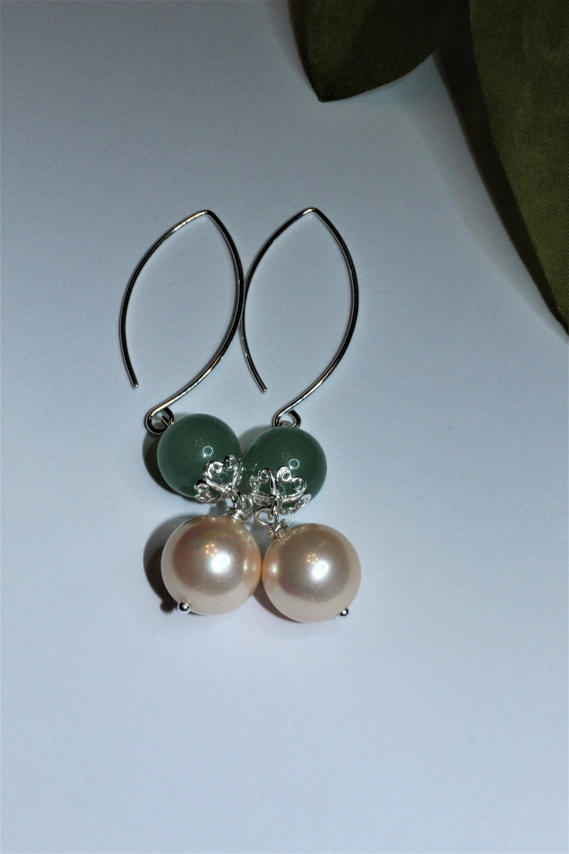 Green Aventurine Earrings with Freshwater Pearl Dangles handcrafted in sterling silver for an elegant, timeless look. These earrings feature natural green aventurine stones paired with lustrous freshwater pearls, symbolizing luck, prosperity, and calm energy. Perfect for adding a touch of sophistication to any outfit, they make a thoughtful gift for women who appreciate handmade gemstone jewelry, natural healing crystals, and classic accessories that blend beauty with spiritual balance.