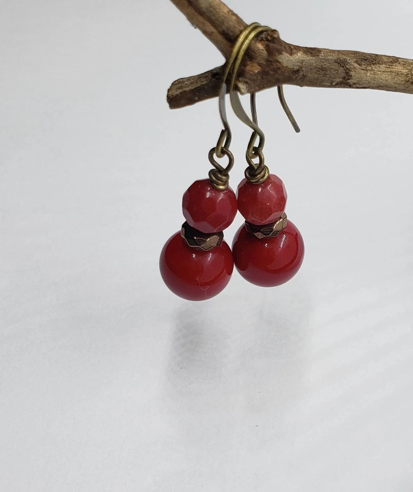 Vintage Tibetan-style hoop earrings crafted with red coral, bronze accents, and red beaded agate stones combined with glass drops. These statement earrings for women feature intricate handcrafted design, blending bold colors and textures for a unique, eye-catching accessory. Perfect for adding a pop of vibrant color to any outfit, these earrings embody ethnic charm and timeless elegance, ideal for special occasions or everyday wear.