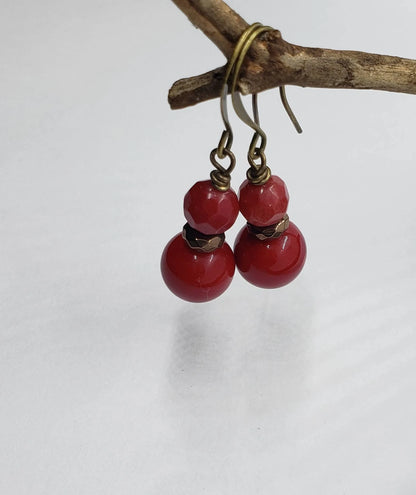 Vintage Tibetan-style hoop earrings crafted with red coral, bronze accents, and red beaded agate stones combined with glass drops. These statement earrings for women feature intricate handcrafted design, blending bold colors and textures for a unique, eye-catching accessory. Perfect for adding a pop of vibrant color to any outfit, these earrings embody ethnic charm and timeless elegance, ideal for special occasions or everyday wear.